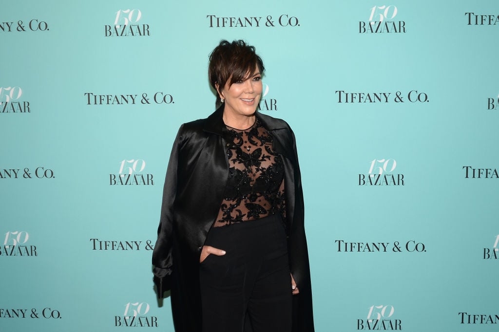 Kris Jenner wearing a black dress and smiling on the red carpet
