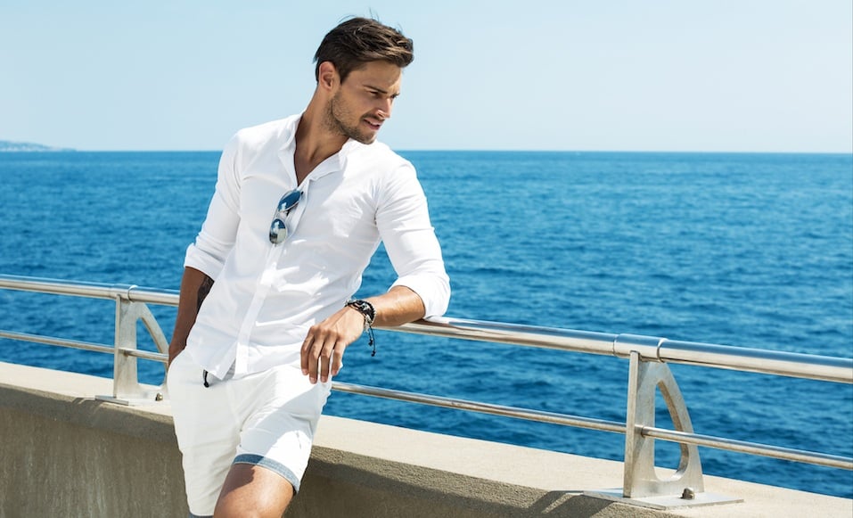 Man wearing white clothes posing in sea scenery