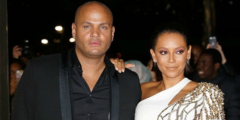 Mel B is in a white gown and Stephen Belafonte is in a black suit on the red carpet.