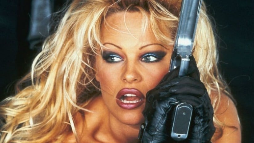 Pamela Anderson holding a gun and wearing gloves in poster art for Barb Wire