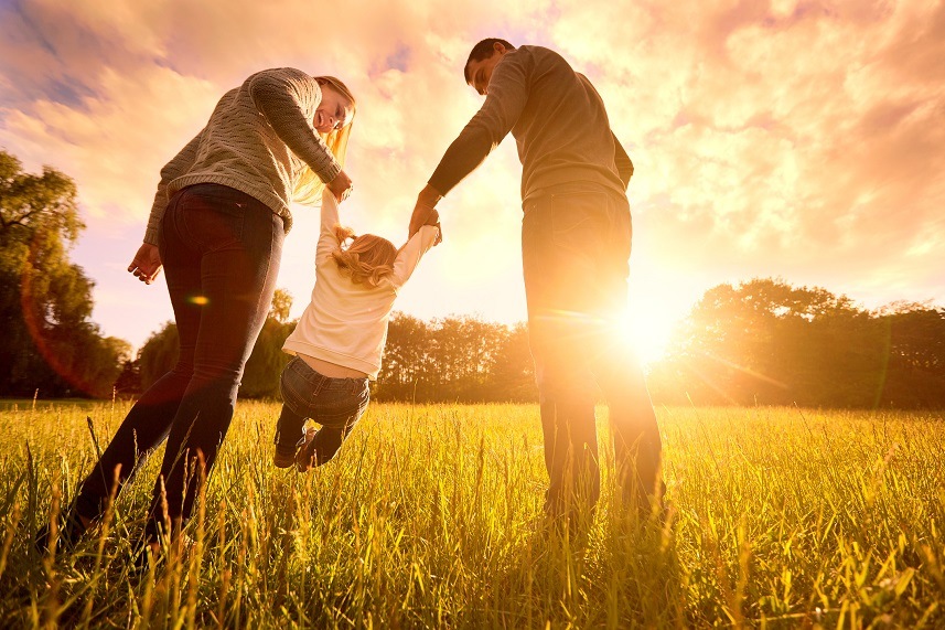 Mom, dad and baby happy walk at sunset