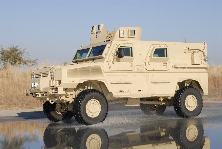 An RG-31 Nyala splashes through a wet road.