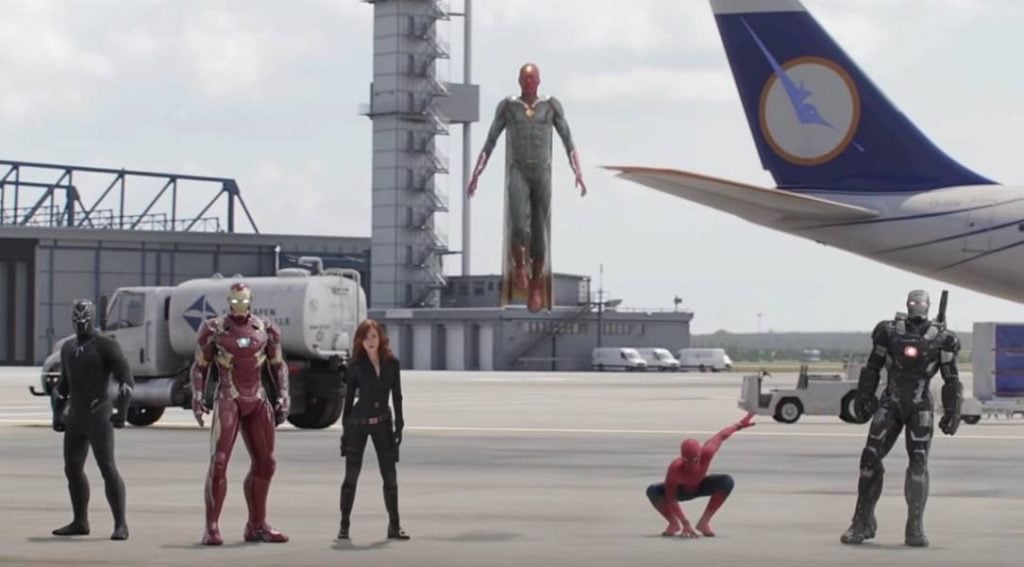 Black Panther, Iron Man, Black Widow, a flying Vision, a crouching Spider-Man, and War Machine together at an airport