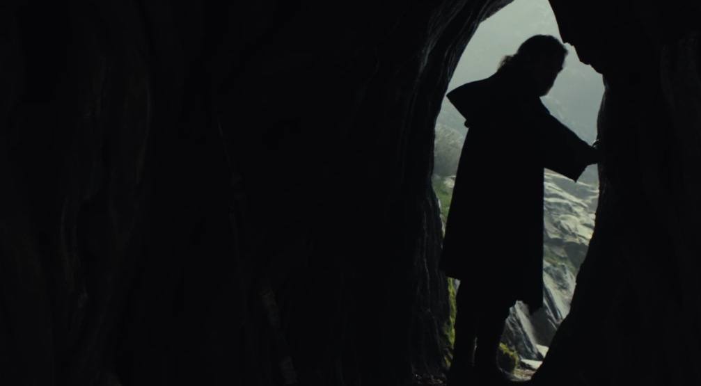 Luke stands silhouetted at the entrance to a cave