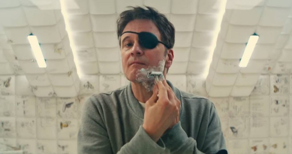 Colin Firth shaving, wearing a white sweatshirt and an eyepatch