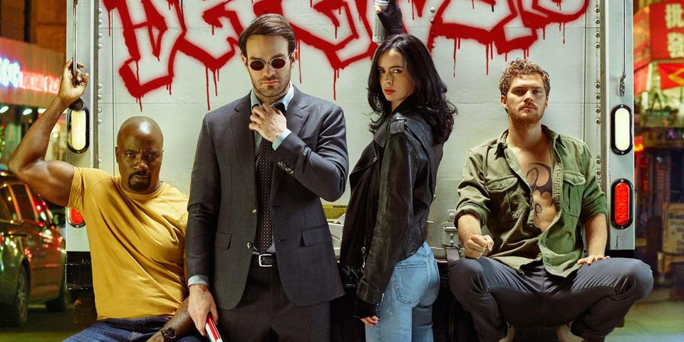 The Defenders sit on the back of a truck, posing for the camera in a press photo