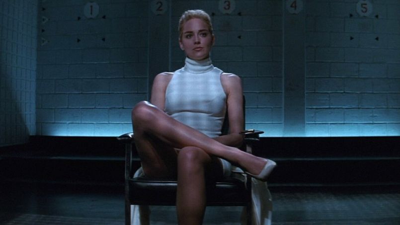 Sharon Stone sitting alone in a chair with her legs crossed