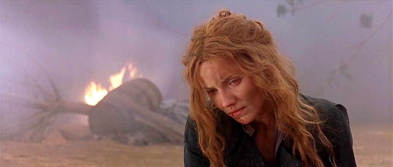 Cameron Diaz as Jenny Everdeane looking down sadly in front of ruins and fire in Gangs of New York