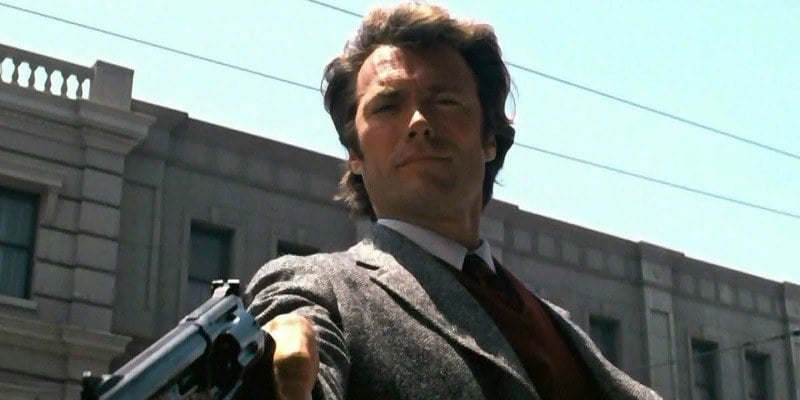 Clint Eastwood as Harry is pointing a gun downward.