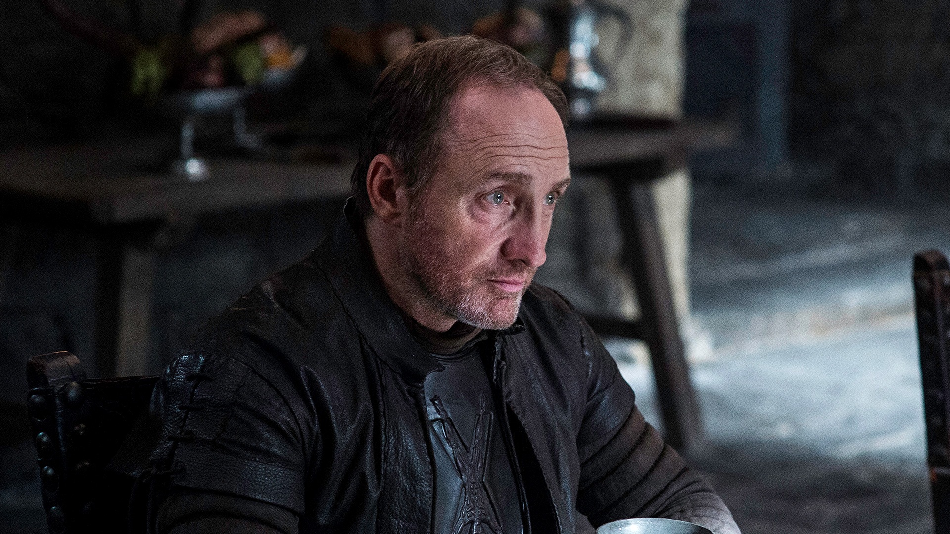 Roose Bolton, sitting at a table, in a scene from 'Game of Thrones.'