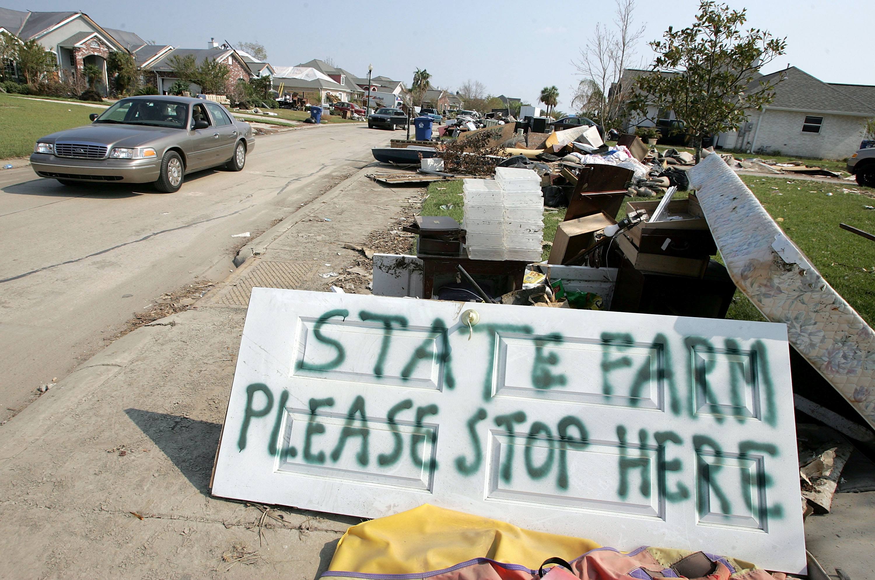 sign that says "state farm please stop here" on a damaged street