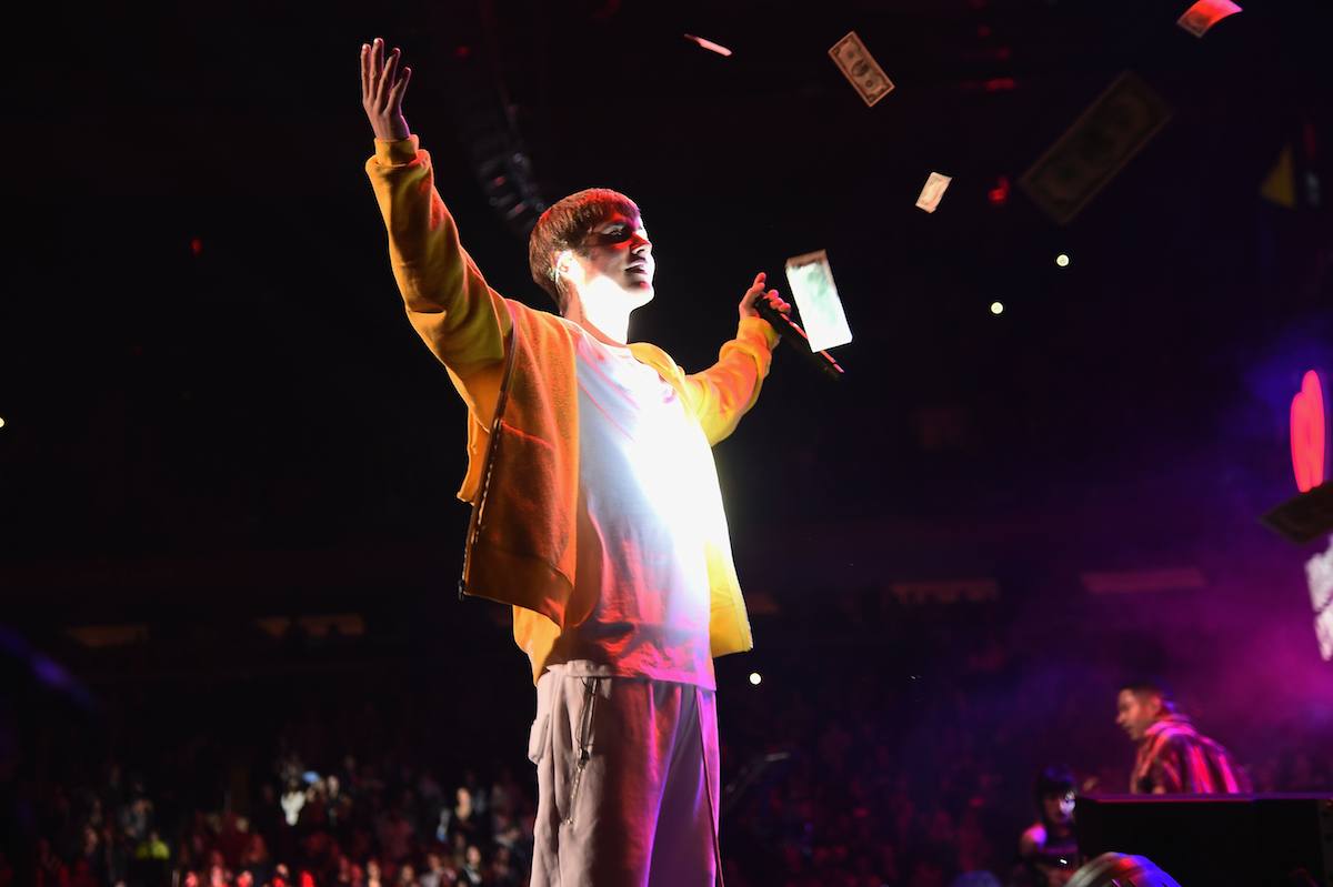 Justin Bieber raises his arms up as money rains down from the ceiling during a performance at the 2009 Z100 Jingle Bell Ball.