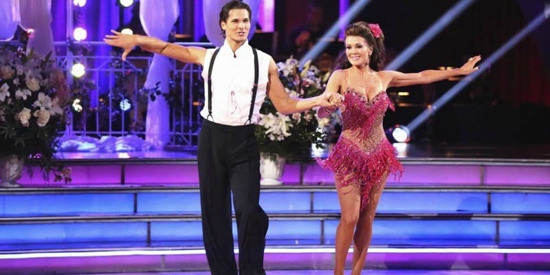 Lisa Vanderpump and Gleb Savchenko are holding hands while dancing on the show.