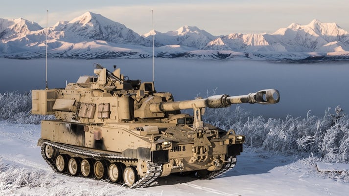 A M109A7 tank drive along a snow covered road.