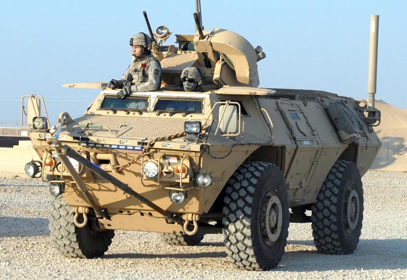 Soldiers look out of the top of an M117 Guardian.