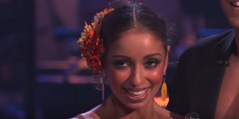There is a closeup of Mya smiling as she's getting feedback from the judges.