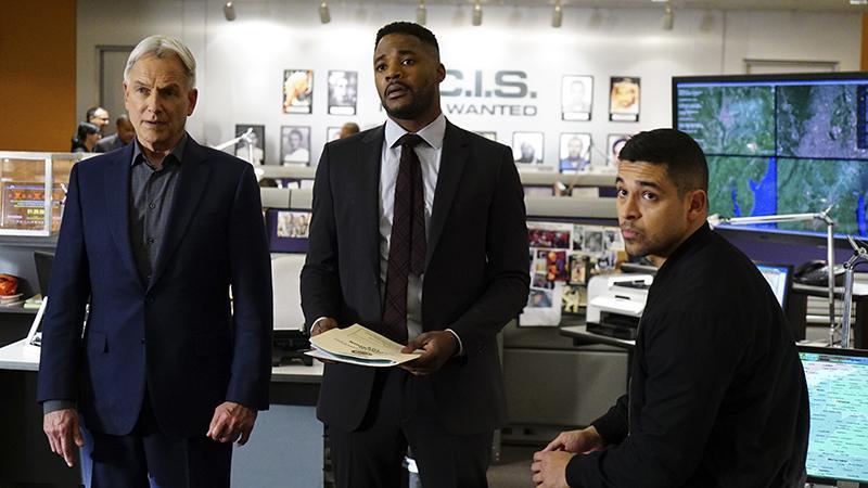 Mark Harmon, Henry Duane and Wilmer Valderrama stand next to each other in an office