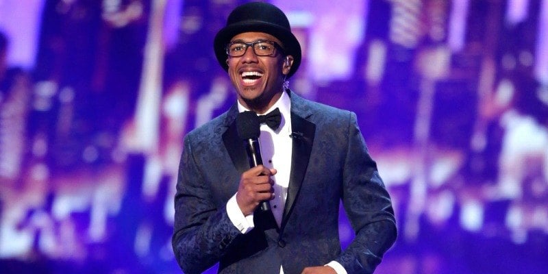 Nick Cannon is holding a microphone on stage of America's Got Talent.