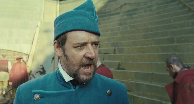 Russell Crowe as Inspector Javert in a blue jacket and cap yelling in Les Misérables