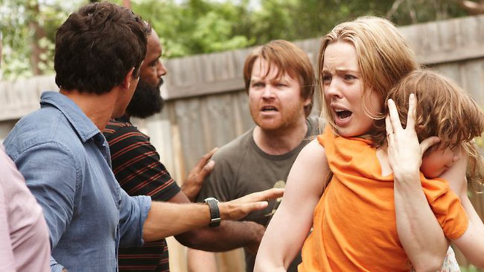 Rosie looks distraught as she clutches Hugo to her chest in the midst of an argument in a scene from 'The Slap.'