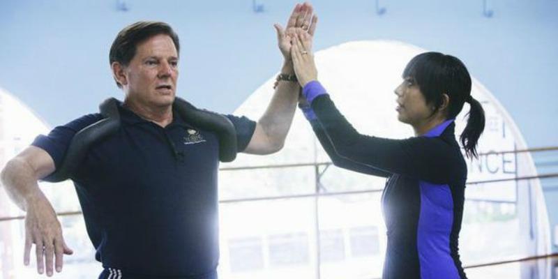 Cheryl Burke is fixing Tom DeLay's form while rehearsing.