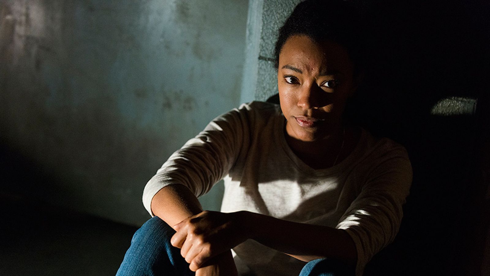 Sasha sits on the floor in the shadows in a scene from Season 7 of 'The Walking Dead.'
