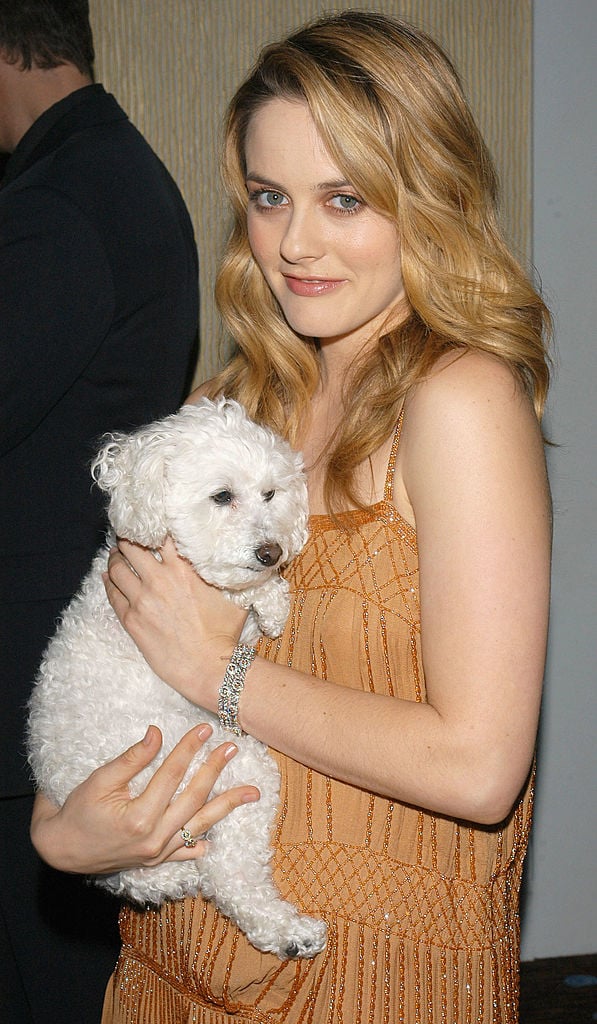 Alicia Silverstone holds a dog.