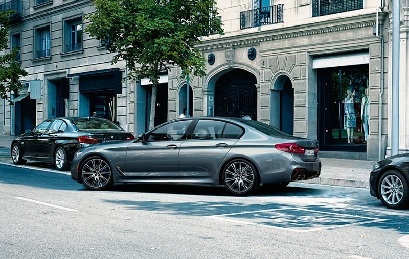 View of 2017 BMW 5 Series sedan parking on a city street