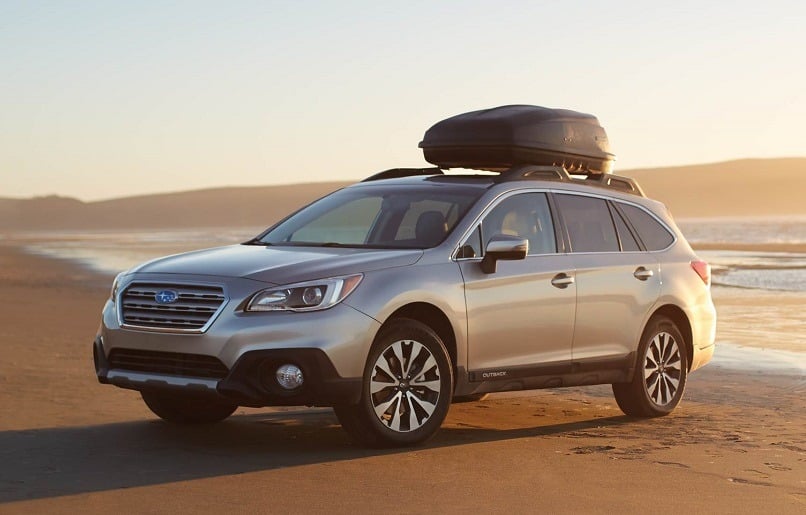 View of Subaru Outback on the beach at sunrise