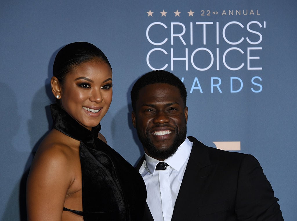 Enika Parrish and Kevin Hart, smiling together for the camera's on the red carpet