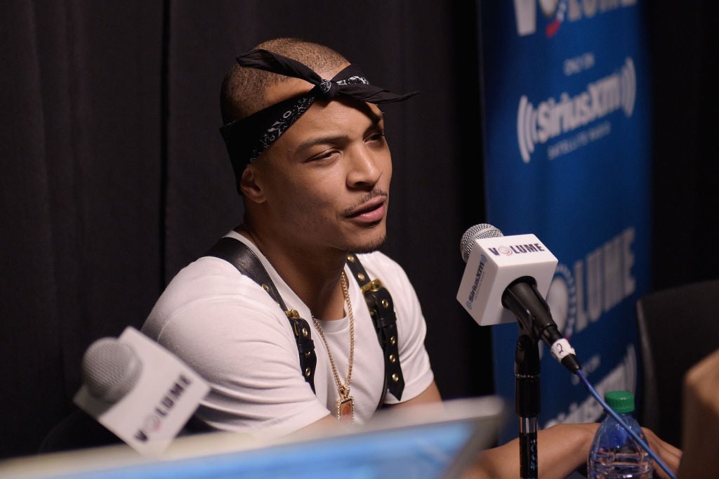 T.I. wearing a black bandana around his head, speaking into a microphone