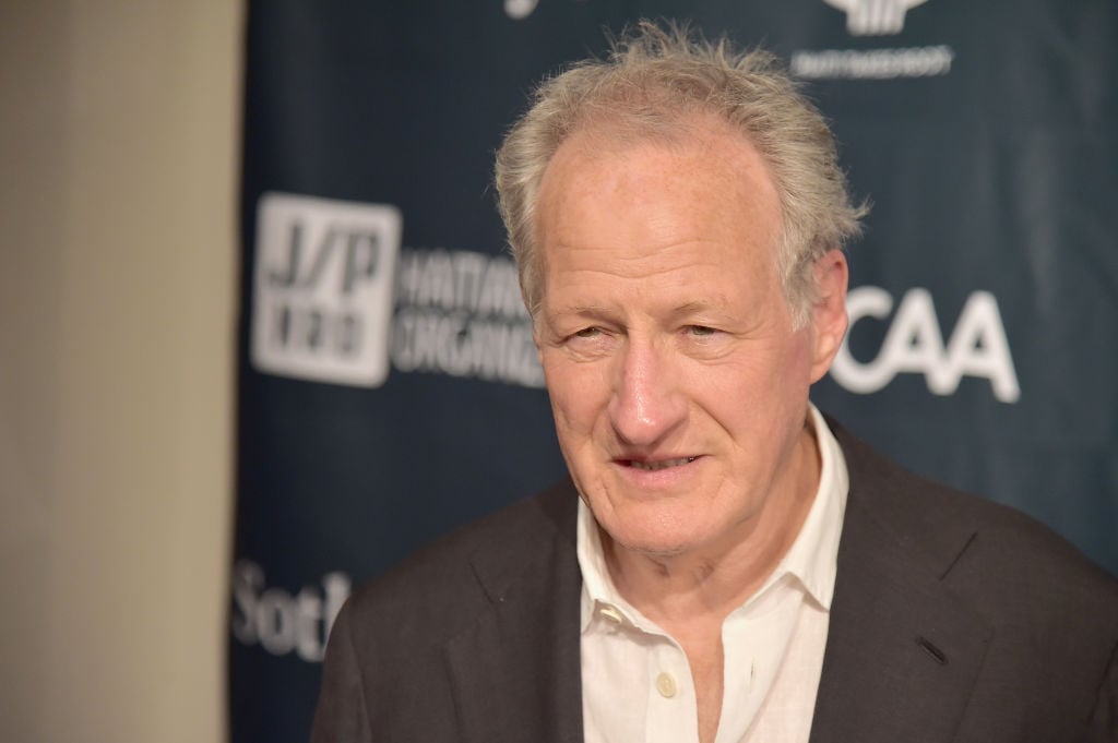 Michael Mann wearing a grey suit jacket and white collared shirt