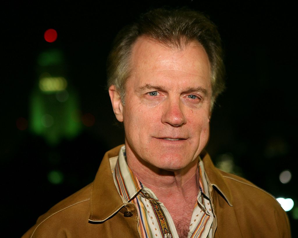 Stephen Collins in a tan jacket and collared shirt, smiling slightly for the camera
