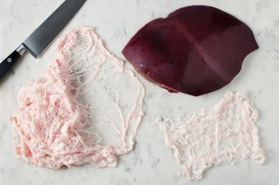 Raw liver and animal fat net on a marble table