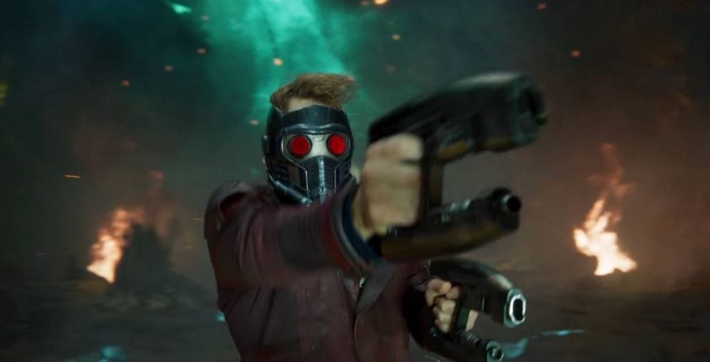 Star-Lord with his red-eyed helmet on, firing his gun