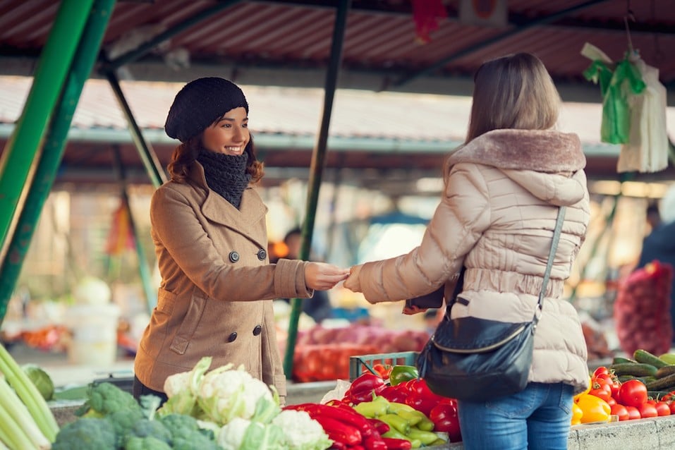 woman in coat buying produce