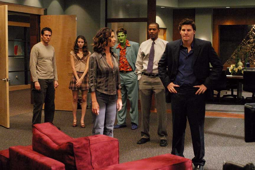 The cast of Angel stands together in a nice office