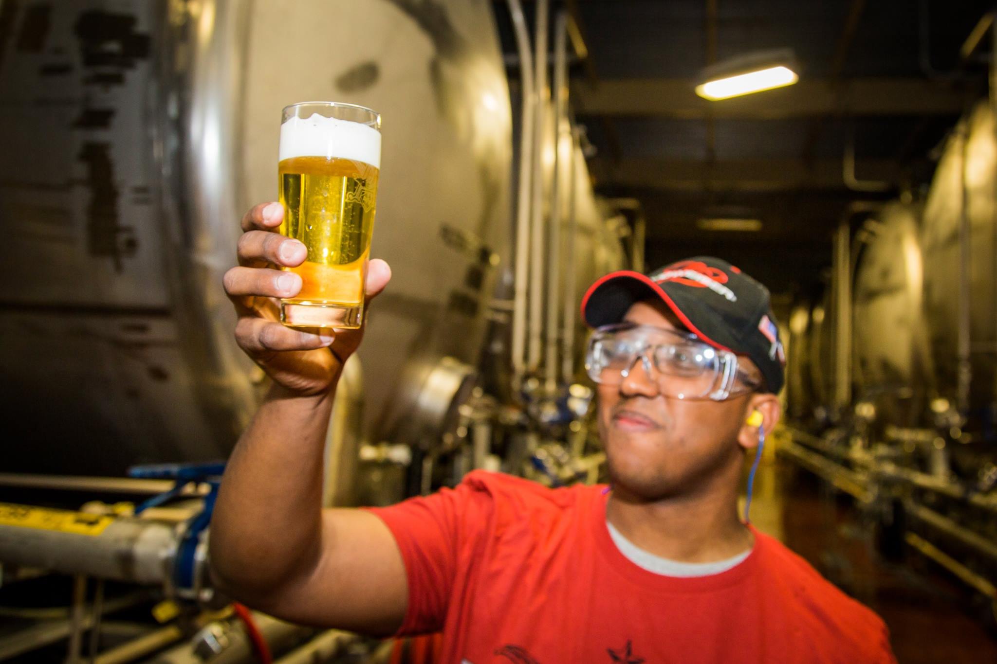 worker holds up beer