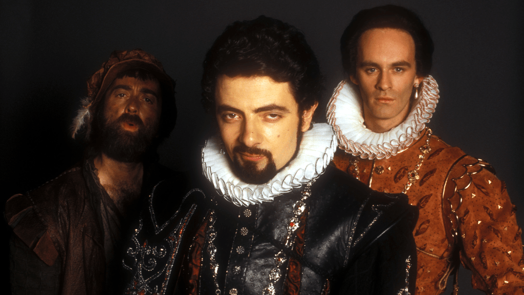 The cast of Blackadder in medieval costumes staring ahead