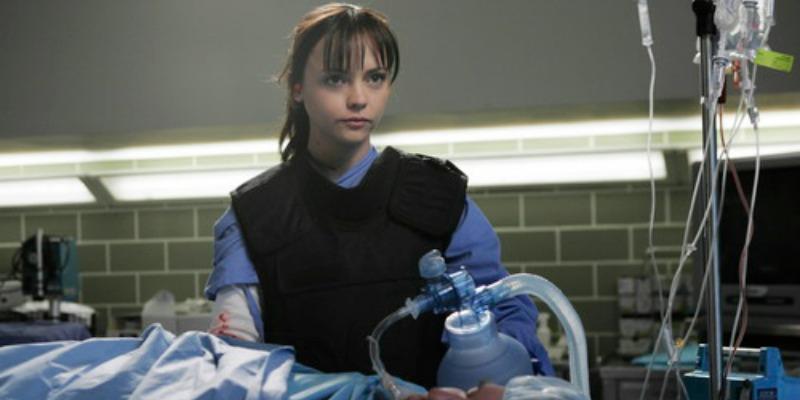 Christina Ricci is wearing a vest while operating on a patient.