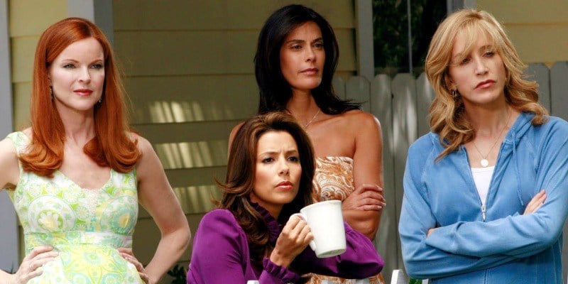 The cast of Desperate Housewives is standing together on someone's front lawn.