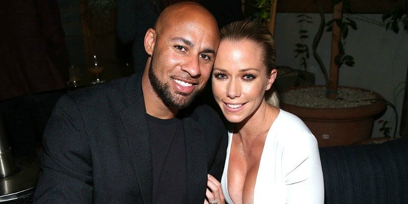 Hank Baskett and Kendra Wilkinson pose together smiling.