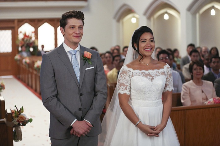 Michael and Jane are crying happy tears standing next to one another in a church at their wedding