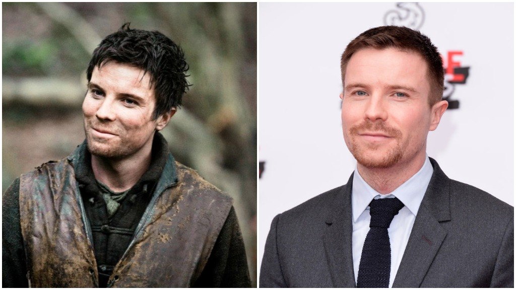 A side-by-side comparison of Joe Dempsie, as Gendry on Game of Thrones, and wearing a suit, sporting a goatee on the red carpet