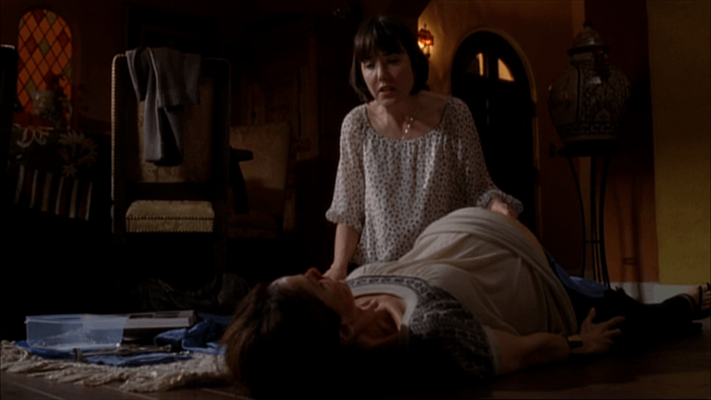 Violet lays pregnant on the floor while Katie touches her belly
