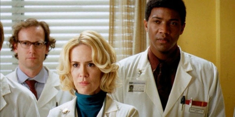 Sarah Paulson is dressed as a doctor along with two other people.