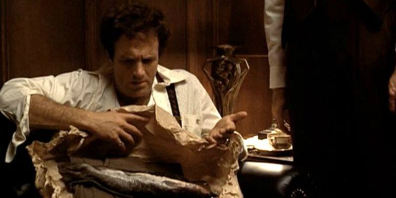 Sonny looks down at a fish wrapped in paper in The Godfather.