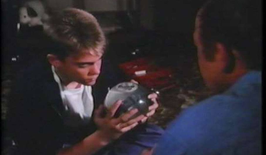 Tommy Westphall staring at snow globe as his father holds it