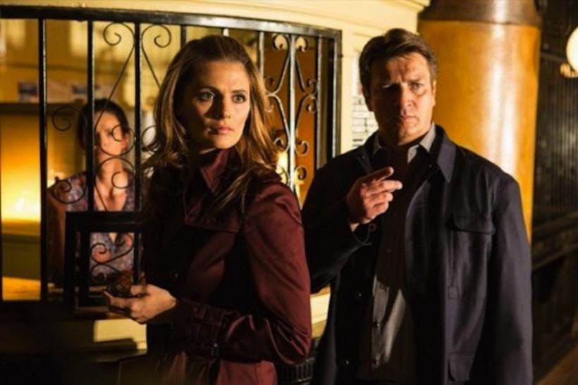 Stana Kanic and Nathan Fillion stand next to each other in a scene from Castle