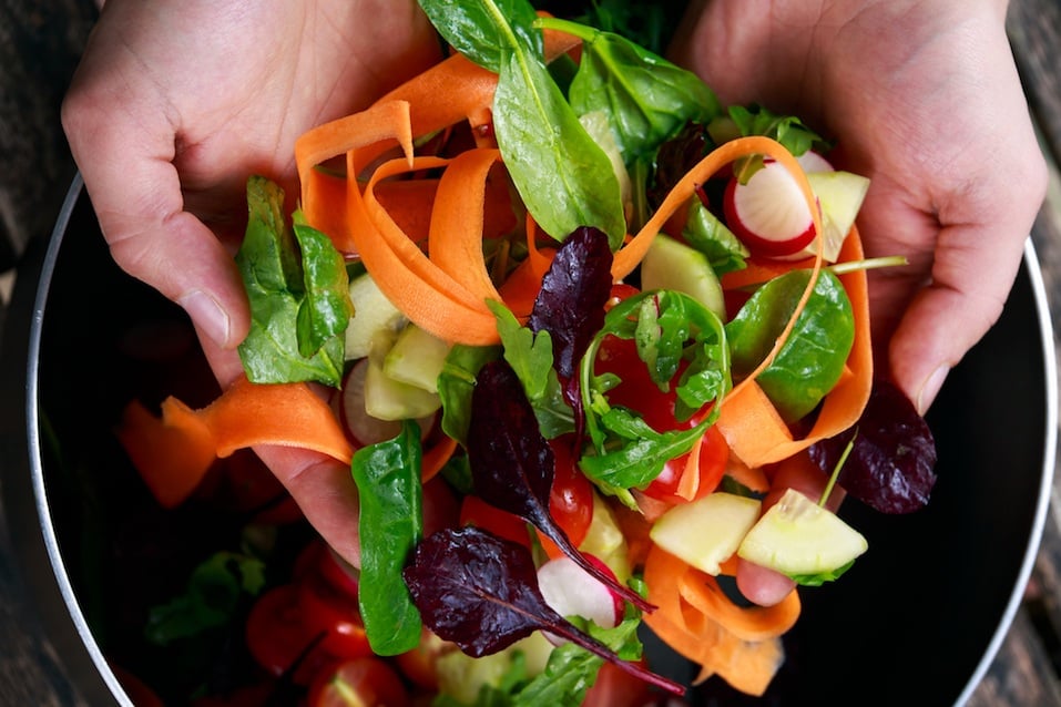 hands tossing a salad